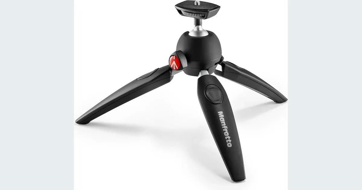 Black Manfrotto PIXI EVO mini tripod with extendable legs and ball head in manufacturer product photography